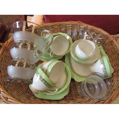 1186 - A wicker and rush basket with Roslyn china part teaset, a lobed glass jug and three matching glasses