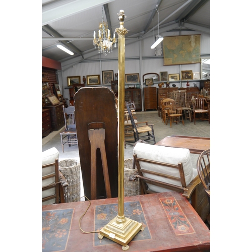 2011 - A brass Corinthium collumn standard lamp on claw feet