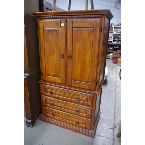 2507 - An Eastern hardwood cupboard over three drawers