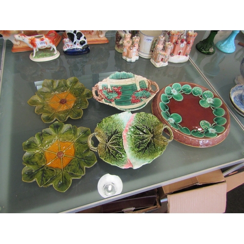 1575 - A pair of Bretby majolica glazed leaf-moulded plates. A similar bread plate moulded with lily pads a... 