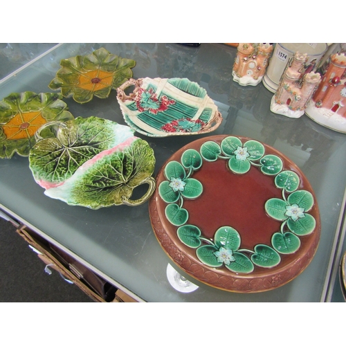 1575 - A pair of Bretby majolica glazed leaf-moulded plates. A similar bread plate moulded with lily pads a... 