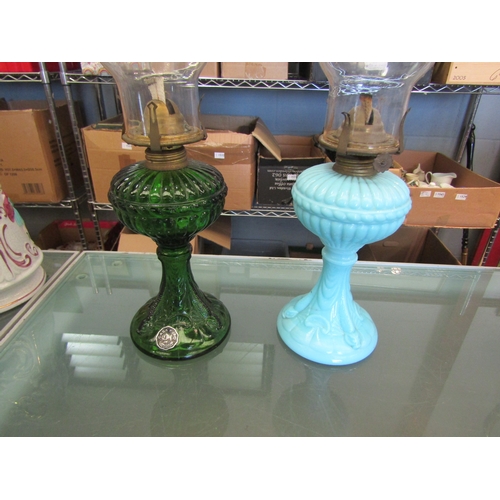 1576 - Two oil lamps in green and opaque blue glass with fluted rim chimneys