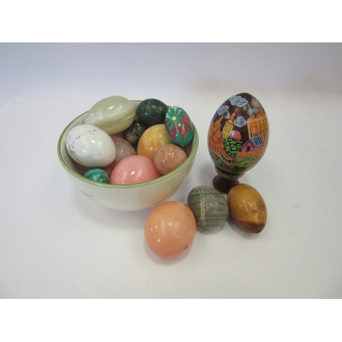 1244 - A small collection of stone and painted wooden eggs