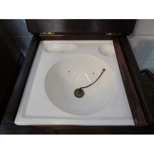 1021 - A late Victorian mahogany campaign wash cupboard with ceramic basin and brass waste