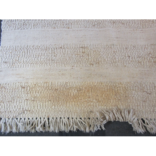 1621 - A large modern beige ground kilim rug with tasselled ends, some discolouration, 370cm x 270cm