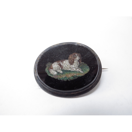 6439 - A 19th Century micro mosaic brooch, black onyx with spaniel design, cracks visible, 4.5cm long