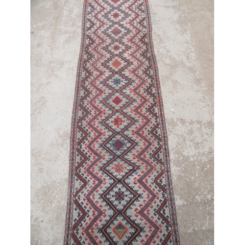 6464 - An early to mid 20th Century slim hand woven runner with lozenge and zig-zag pattern 378cm x 58cm