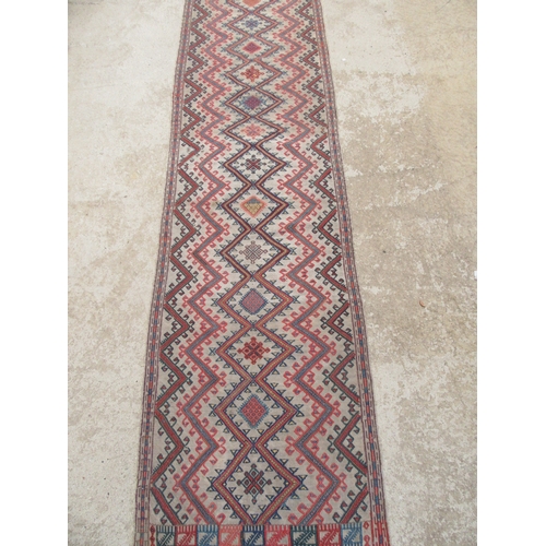 6464 - An early to mid 20th Century slim hand woven runner with lozenge and zig-zag pattern 378cm x 58cm