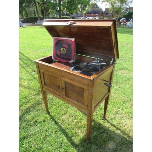 7432 - An early 20th Century gramophone, housed in oak case raised on square tapering legs to spade feet, t... 