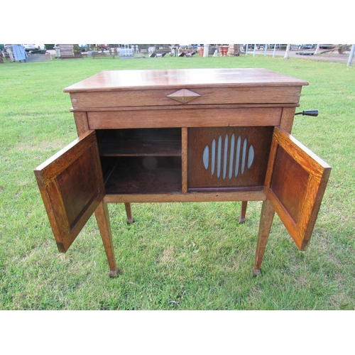 7432 - An early 20th Century gramophone, housed in oak case raised on square tapering legs to spade feet, t... 