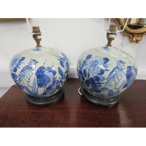 6064 - A pair of blue and white ginger jars as table lamps with blossom, bird and leaf decoration, circular... 