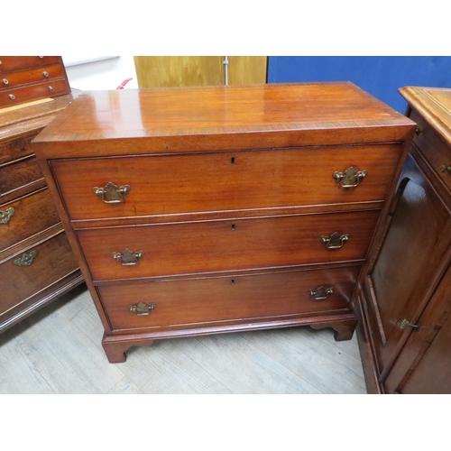 6082 - A 19th Century mahogany chest of three graduating long drawers with rosewood crossbanding over brack... 