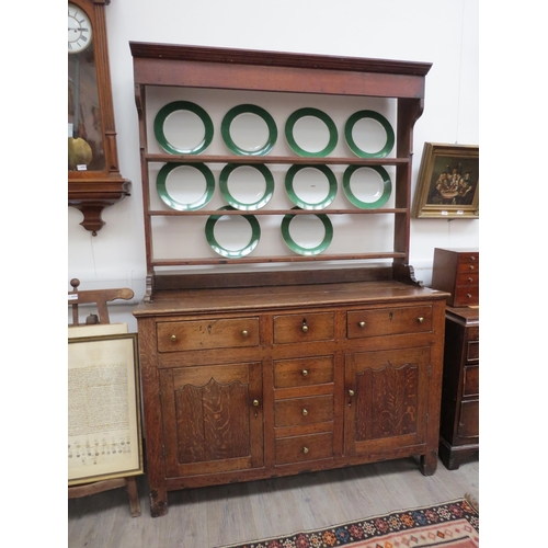 6091 - A Georgian country house oak dresser, the open plate rack top over a six drawer and two door cupboar... 