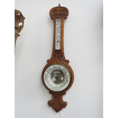 6097 - An early 20th Century carved oak cased barometer with thermometer dial