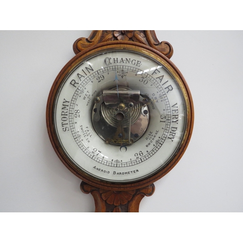 6097 - An early 20th Century carved oak cased barometer with thermometer dial