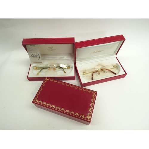 6363 - CARTIER, a pair of titanium 135 framed glasses and three Cartier glasses cases with a pair of Henrik... 