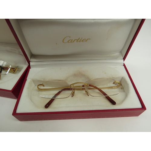 6363 - CARTIER, a pair of titanium 135 framed glasses and three Cartier glasses cases with a pair of Henrik... 