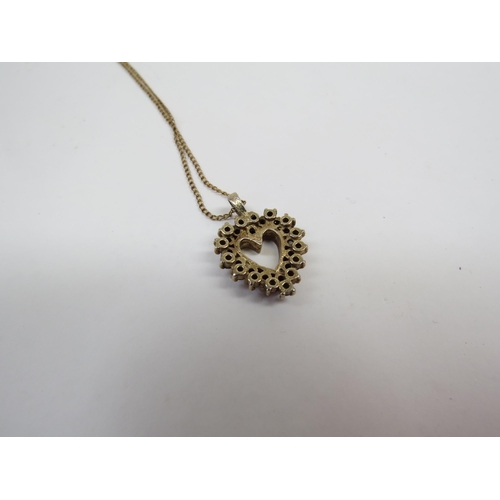 6413 - A 12ct gold chain hung with a heart form pendant