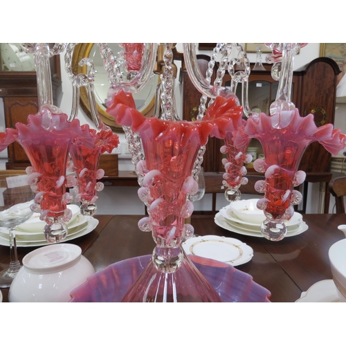 6263 - A highly ornate glass epergne, ten red/pink glass trumpets with frilled edges, nine of which hung on... 