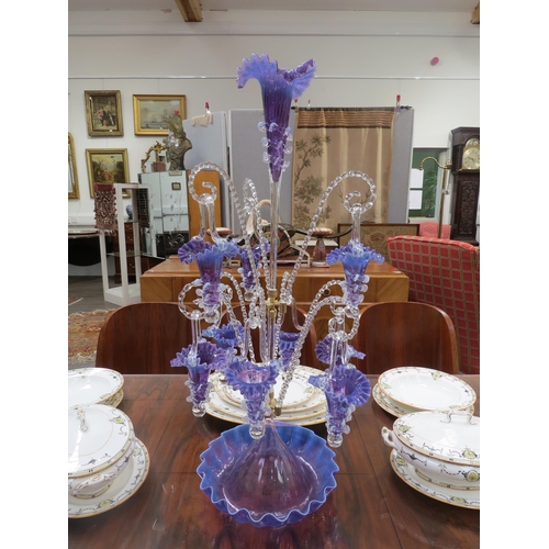 6267 - A highly ornate glass epergne, ten purple/mauve glass trumpets with frilled edges, nine of which hun... 