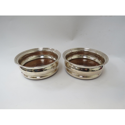 6339 - A pair of Garrard and Co Britannia Standard silver wine coasters, London 1977, 14.5cm diameter