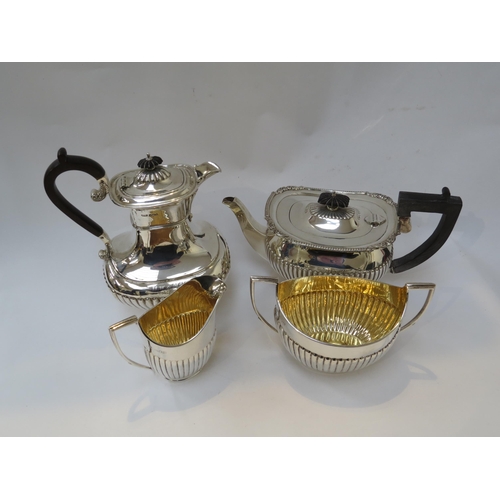 6386 - A silver matched four piece tea set with melon fluting, inscription to water jug, 1488g approx