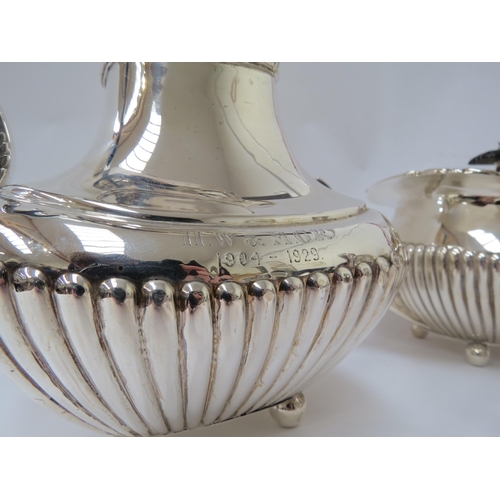 6386 - A silver matched four piece tea set with melon fluting, inscription to water jug, 1488g approx