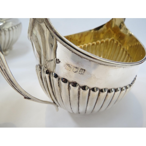 6386 - A silver matched four piece tea set with melon fluting, inscription to water jug, 1488g approx