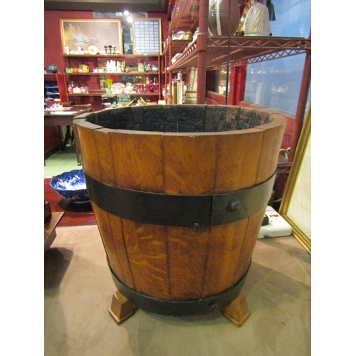 4014 - An oak coopered well bucket raised on four feet, 38cm tall x 38cm diameter