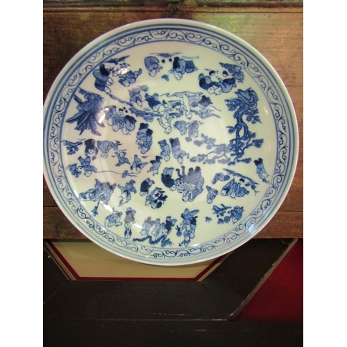 4052 - A 20th Century Oriental blue and white charger decorated with various scenes including children play... 