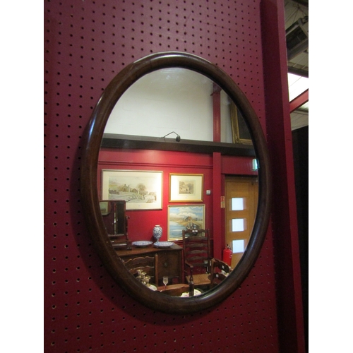 4053 - An oval mahogany framed wall mirror, 50cm x 40cm