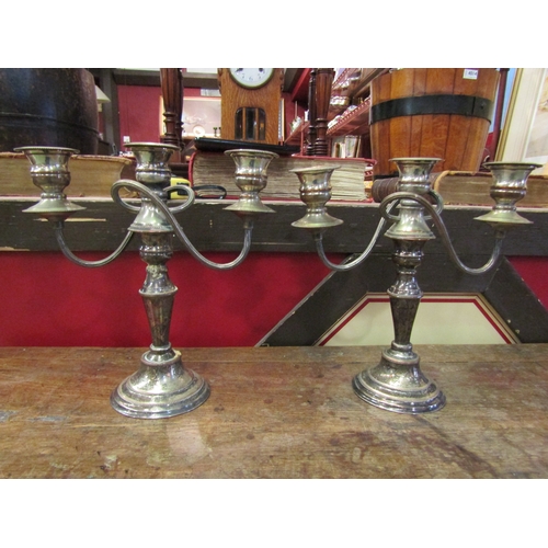 4065 - A pair of silver-plated copper three-arm candlesticks, 27cm tall