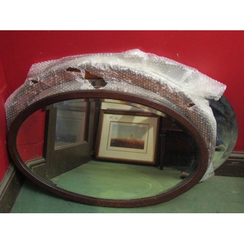 4088 - Two oak framed oval wall mirrors with a large unframed bevel-edged mirror glass (3)