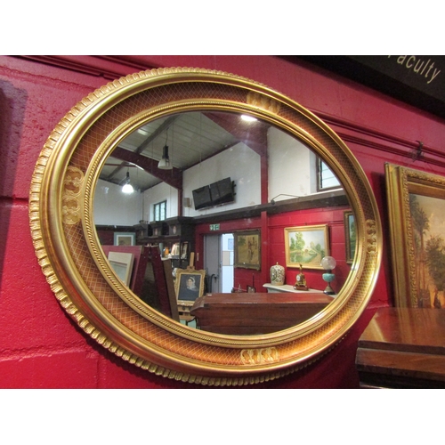 4125 - A reproduction oval gilt wall mirror, approximately 65cm x 85cm