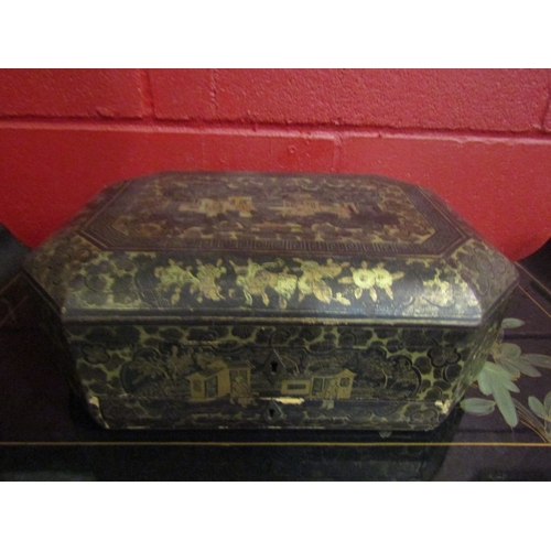 4140 - An Oriental black lacquered octagonal box with gilded decoration. Approximately 33cm x 24cm. Key mis... 