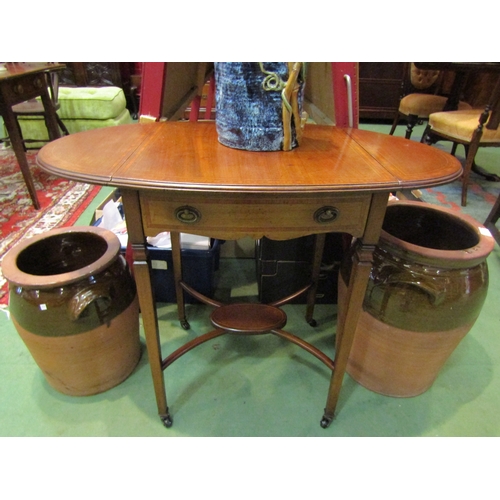 4179 - An Edwardian crossbanded mahogany oval top side/lamp table, the rising leaves over a single bow fron... 