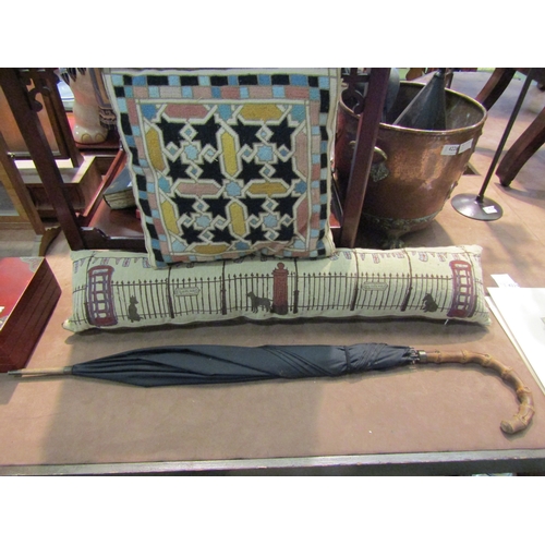 4230 - A vintage black umbrella, a draught excluder, 86cm long, and a tapestry cushion of geometric form (3... 