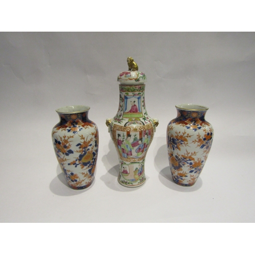 4426 - A pair of imari pattern vases, 18.5cm tall, and a lidded jar decorated in scenic panels and having g... 