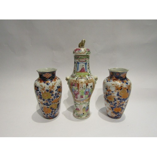 4426 - A pair of imari pattern vases, 18.5cm tall, and a lidded jar decorated in scenic panels and having g... 