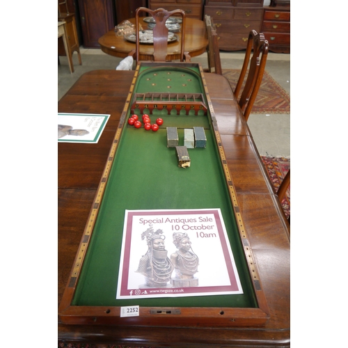 2252 - An Edwardian mahogany fold over games table with green baize, two games included with balls