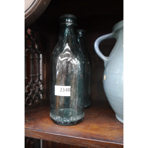 2340 - A pair of vintage milk bottles