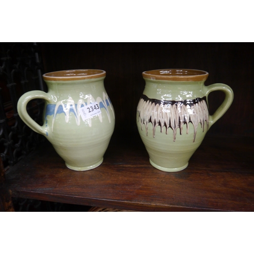 2343 - A pair of green drip glazed single handled jugs