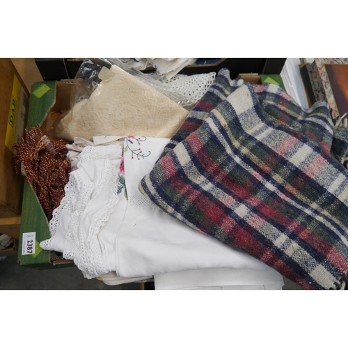 2387 - A box of lace and table cloths material etc