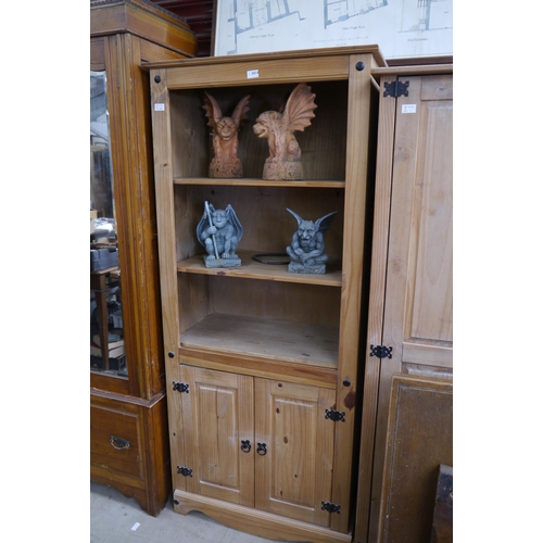 2414 - A pine full height bookcase with two door cupboard base