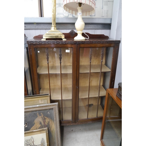 2426 - A glazed display cabinet on ball and claw feet, with key