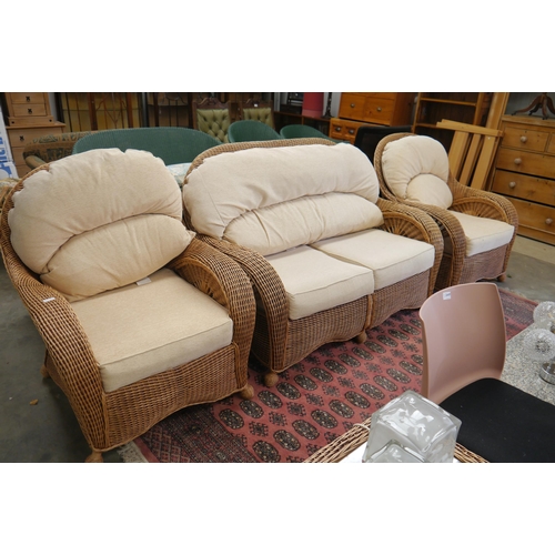 2447 - A canework conservatory suite consisting of two seater sofa, a pair of armchairs, a matching footsto... 