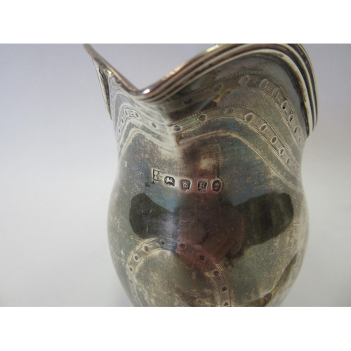 1306 - A George III silver jug, London 1800, maker's marks rubbed, and a fruit knife with mother-of-pearl h... 