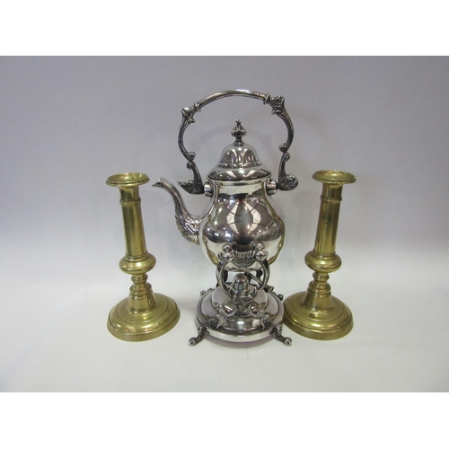 1359 - An ornate silver plated spirit kettle on stand and a pair of brass candlesticks (3)