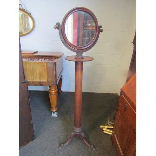 1004 - An early 19th Century mahogany shaving stand with a circular swing mirror, plain cylindrical column ... 