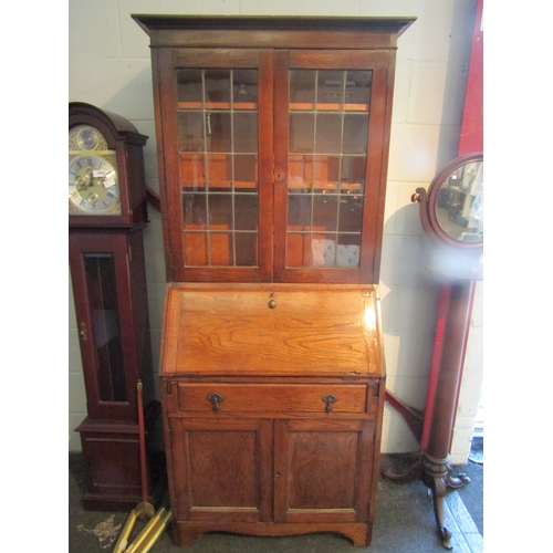 1005 - A 1920's oak full height bureau bookcase, the lead glazed top over base with fall front over a singl... 